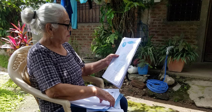 Doña Cándida Rosa muestra documentos legales que demuestran el préstamo. Foto: Roberto Mora/Radio ABC Stereo